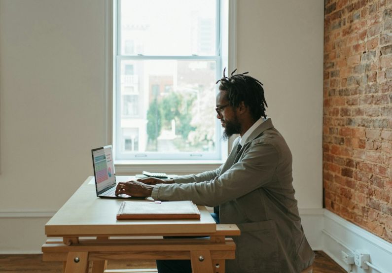 Home Office - a person sitting at a desk with a laptop and papers