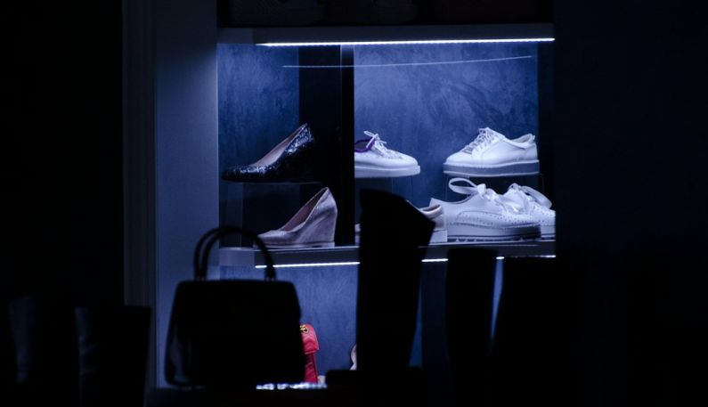 Choosing Sneakers - lit shoe display collection inside a dark room