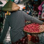 Food Travel - woman carrying basket with vegetables