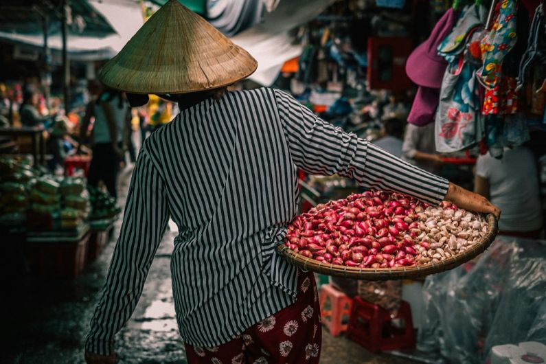 Food Travel - woman carrying basket with vegetables