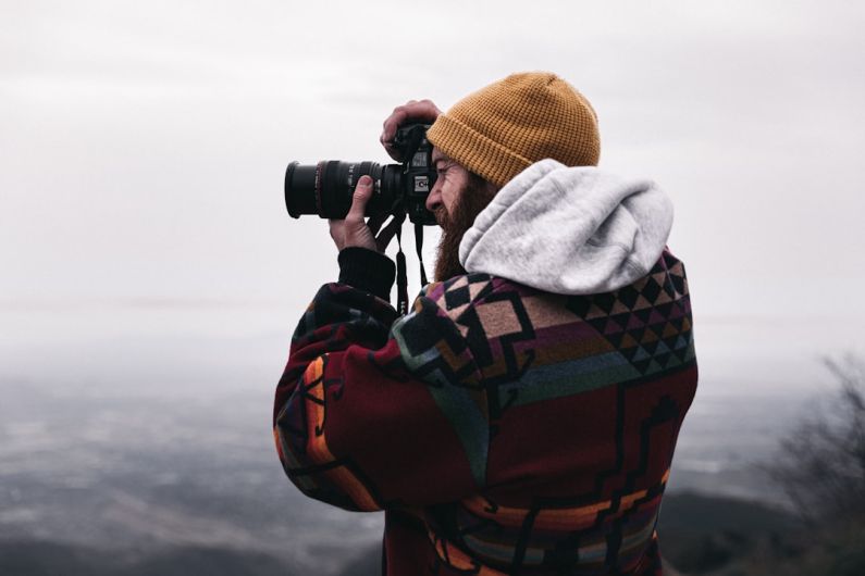 Travel Photography - person in gray hoodie using black binoculars