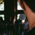 Public Speaking - man standing in front of microphone
