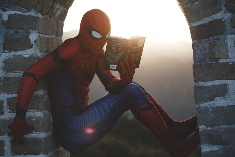Making Comics - Spider-Man leaning on concrete brick while reading book