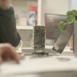 Sustainable Crafting - a person writing on a piece of paper next to a plant