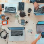 Remote Work Gadgets - people sitting down near table with assorted laptop computers